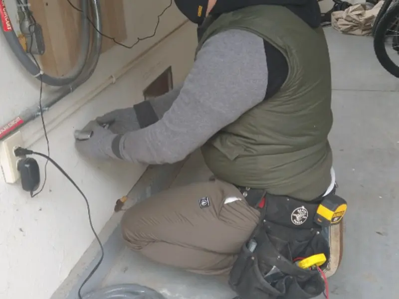 Electrician performing outlet wiring in a Maurice garage